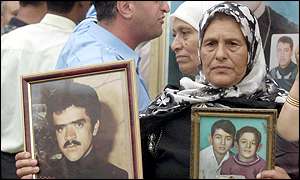 Palestinian woman holds photos of family members killed in the Beirut refugee camps